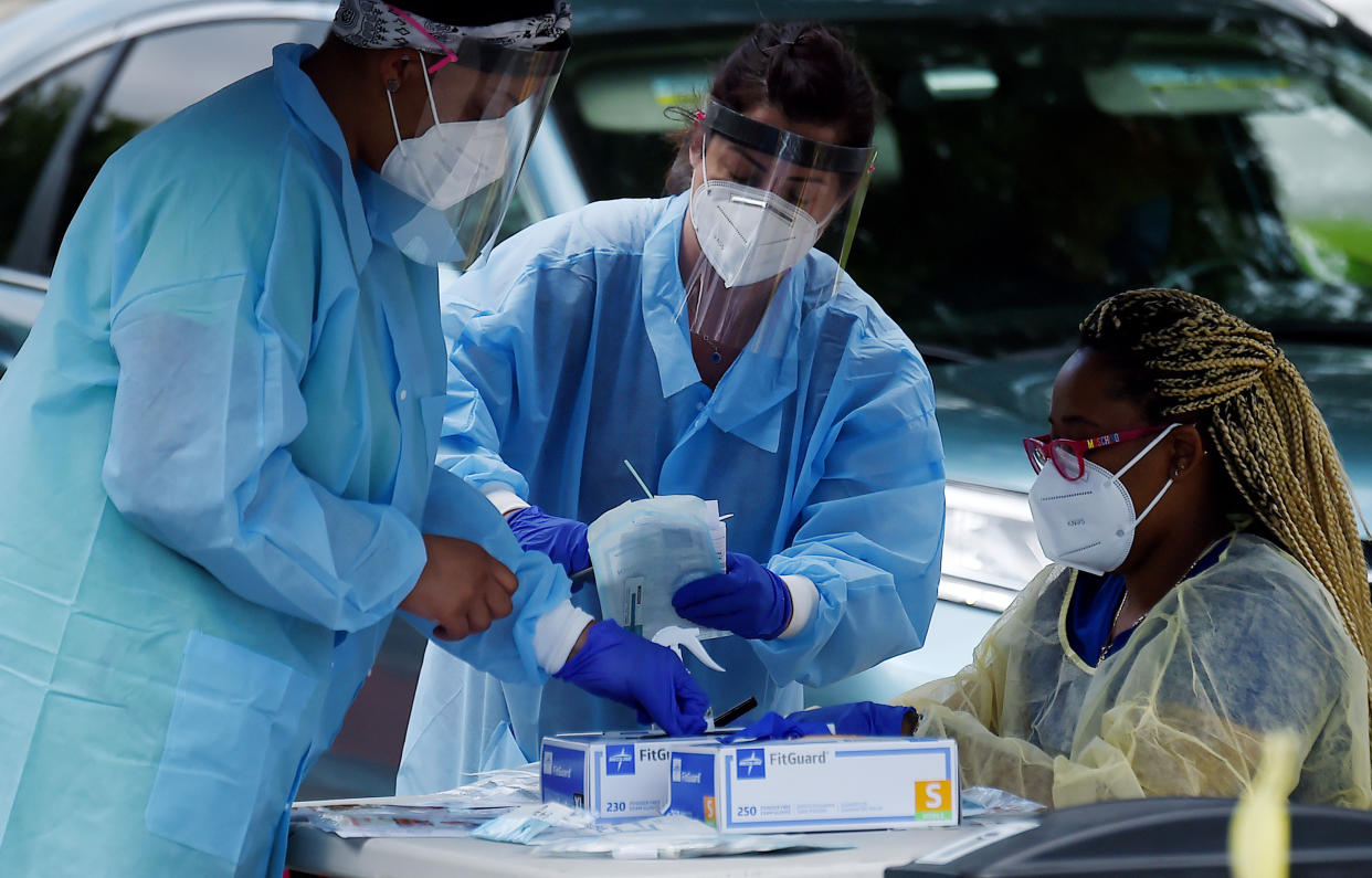 Health workers prepare to give people free COVID-19 tests without needing to show ID, doctor's note or symptoms at a drive-through and walk up Coronavirus testing center located at Barcroft Community Center in the Arlington, Virginia, zip code with the highest concentration of Coronavirus cases in on May 26, 2020. (Olivier Douliery/AFP via Getty Images)