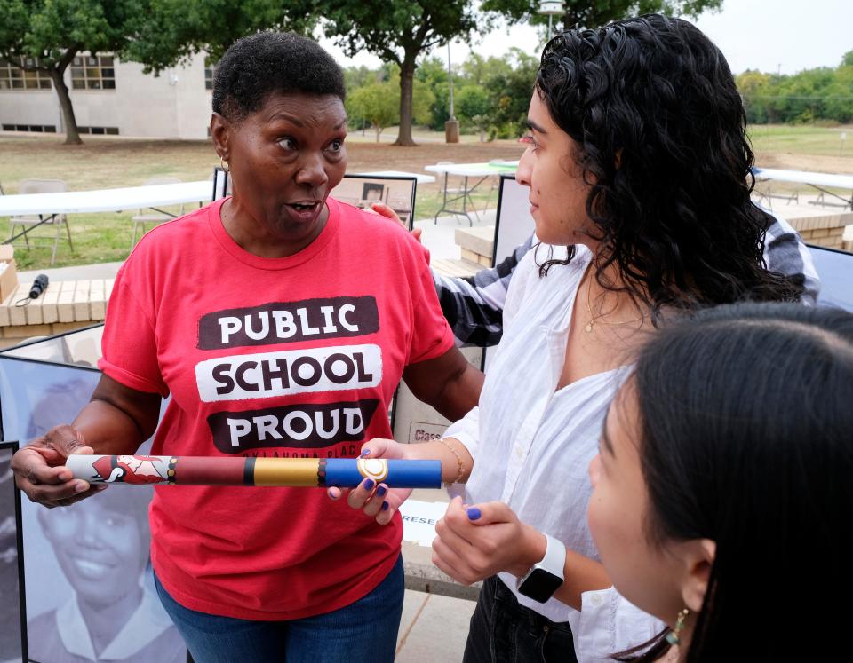 Northeast High School 1970 graduate Brenda Loggins passes a baton to Nazgol Missaghi, the junior class vice president at Classen High School of Advanced Studies at Northeast. Alumni celebrated the new Northeast Legacy Plaza on Friday, Oct. 7, 2022, and reenacted their 1970 march to the state Capitol.