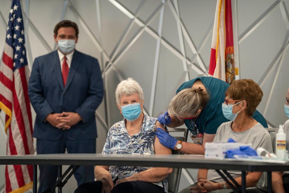 Florida Gov. Ron DeSantis watches Jessica Brown, 77, receive the Moderna COVID-19 vaccine from nurse Sherry Phillips in this 2020 photo at the Kings Point clubhouse in Delray Beach.