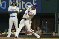 Texas Rangers Kole Calhoun hits a sacrafice fly during the first inning of a baseball game against the Los Angeles Angels in Arlington, Texas, Monday, May 16, 2022. (AP Photo/LM Otero)