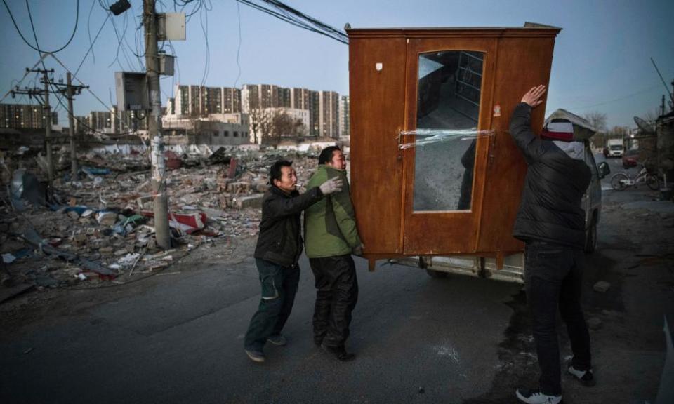 Migrant workers from Anhui load furniture on a truck after being evicted from their home in the Daxing district of Beijing.