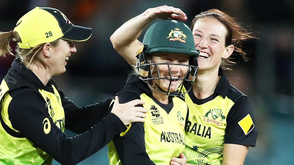 Alyssa Healy smiles celebrates with team mates.