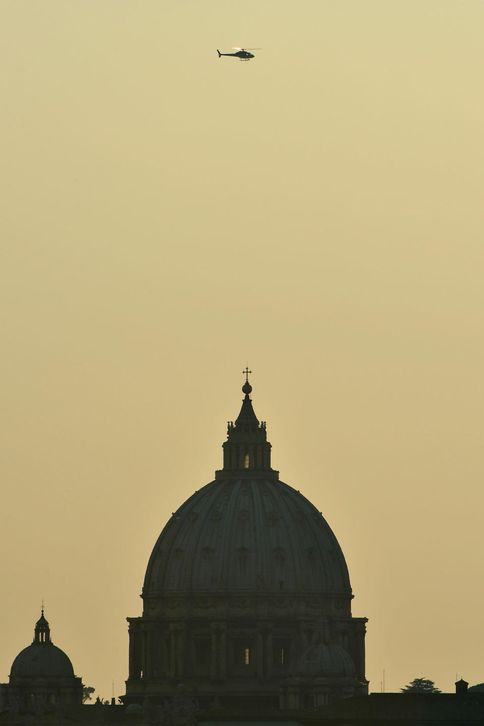 L'hélicoptère qui doit emmener Benoît XVI à la résidence d'été du pape passe au-dessus de la basilique Saint Pierre au Vatican. GABRIEL BOUYS/AFP