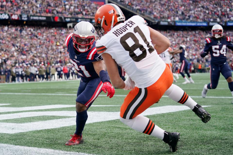 Cleveland Browns tight end Austin Hooper (81) hangs onto the ball for a touchdown reception against New England Patriots safety Adrian Phillips (21) during the first half of an NFL football game, Sunday, Nov. 14, 2021, in Foxborough, Mass. (AP Photo/Steven Senne)