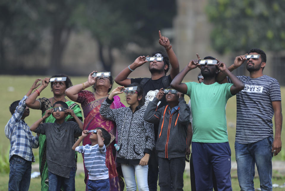 Indians watch a partial solar eclipse in Hyderabad, India, Thursday, Dec. 26, 2019. (AP Photo/Mahesh Kumar A.)