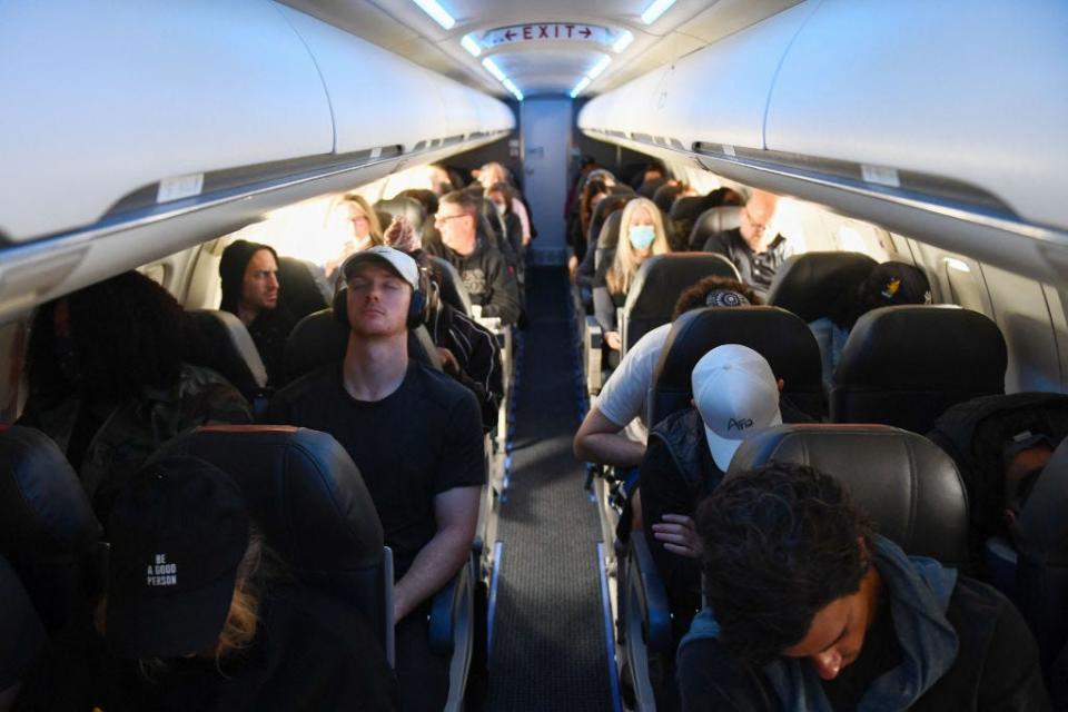 Airline passengers sit on a American Airlines flight operated by SkyWest Airlines on April 19, 2022, after the lifting of the mask mandate.