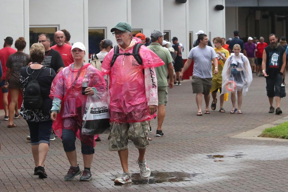 Fans gather around the NASCAR garages on Saturday afternoon as showers slow activities around Daytona International Speedway. The rain-delayed race helped boost food and beverage sales at Daytona Beach-area hotels that were generally sold-out for the race weekend.