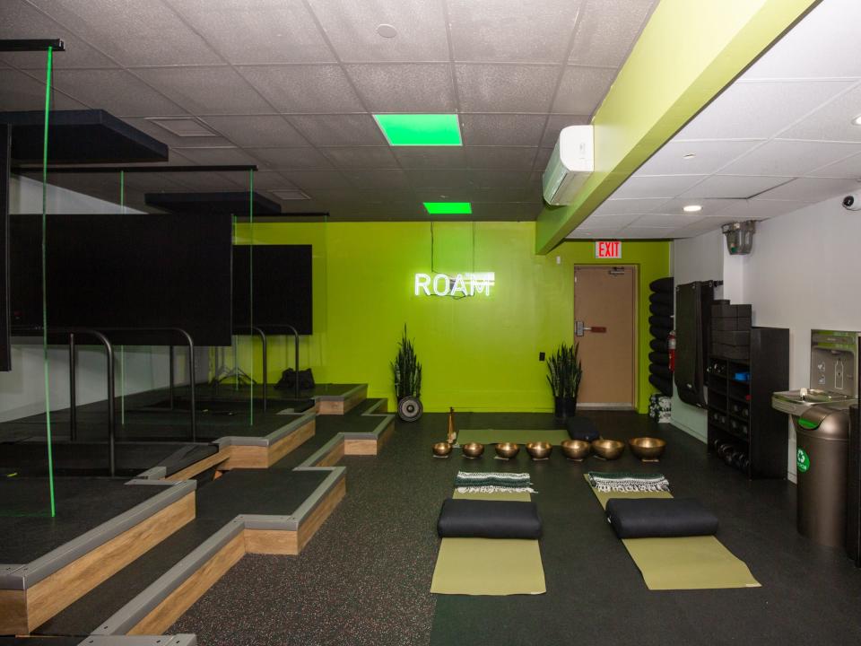 Inside Roam149's gym with yoga mats, treadmills, weights.