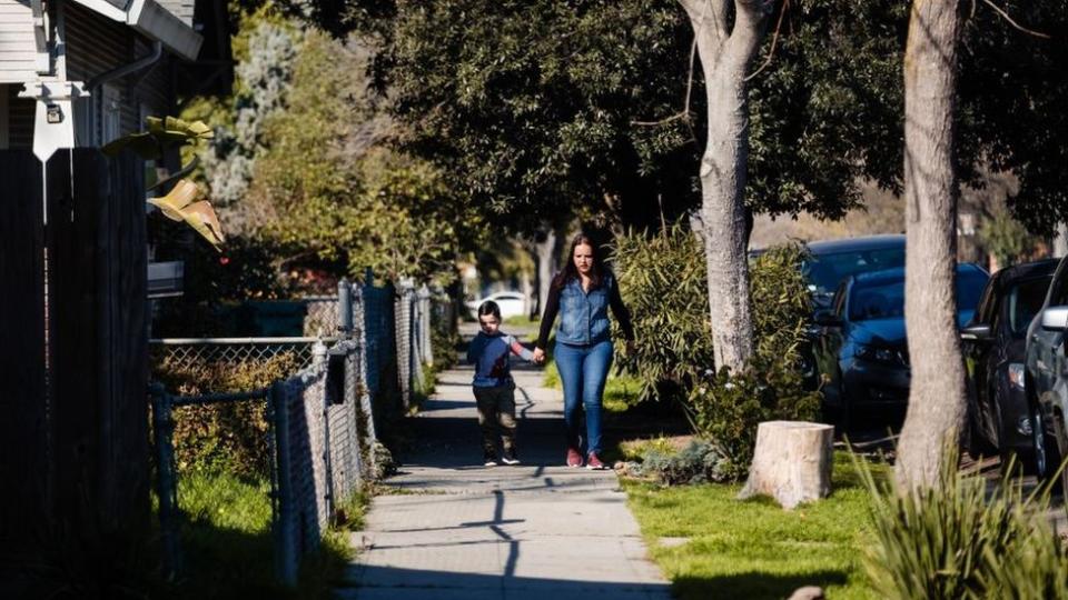 Madre con hijo caminando en la calle. Foto genérica.