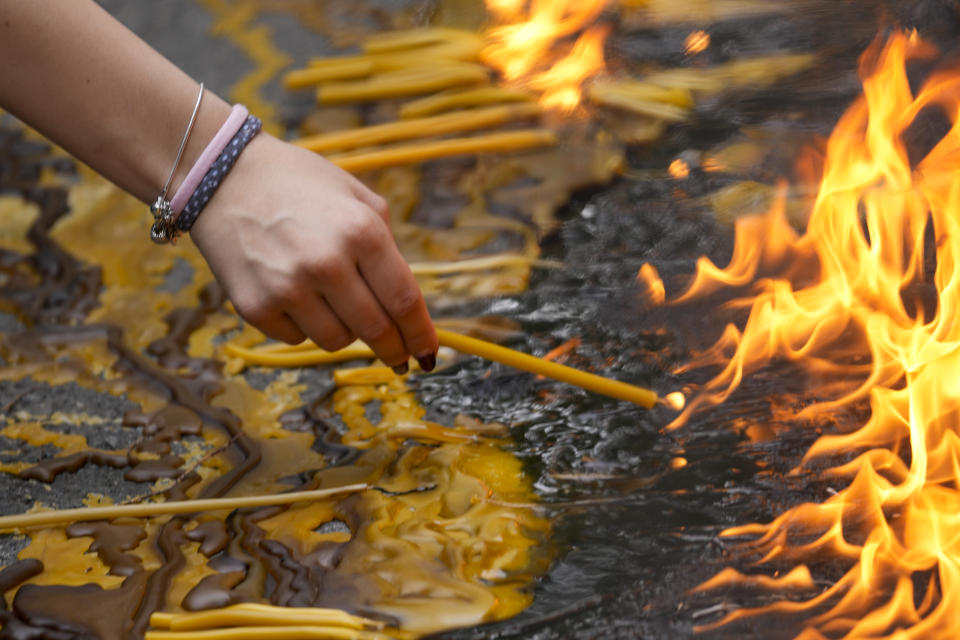 People light candles for the victims in front of the Vladimir Ribnikar school in Belgrade, Serbia, Thursday, May 4, 2023. A 13-year-old opened fire Wednesday at his school in Serbia's capital. He killed eight fellow students and a guard before calling the police and being arrested. Six children and a teacher were also hospitalized. (AP Photo/Darko Vojinovic)