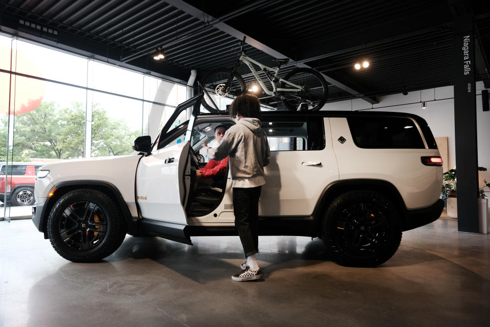 NEW YORK, NEW YORK - JUNE 23: People look at Rivian electric trucks at the auto maker's newly opened storefront in the Meatpacking District of Manhattan on June 23, 2023 in New York City. The 5,000-square-foot location, Rivian’s first on the East Coast, displays its R1T and R1S electric vehicles and offers merchandise, test drives and a lounge and activity space for children. The Manhattan showroom is a temporary location until Rivian opens its permanent New York location in Brooklyn’s trendy Williamsburg neighborhood.  (Photo by Spencer Platt/Getty Images)