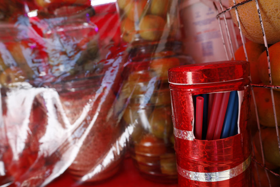 Plastic straws are offered for clients at a street juice stand in central Mexico City, Friday, Jan. 1, 2021. The few street food vendors out working on New Year's Day amid the COVID-19 pandemic said they were either unaware of or were still figuring out how to comply with a broad ban on single-use containers, forks, straws, and other ubiquitous items that took effect Friday in Mexico's capital, one of the world's largest cities, after more than a year of preparation. (AP Photo/Rebecca Blackwell)