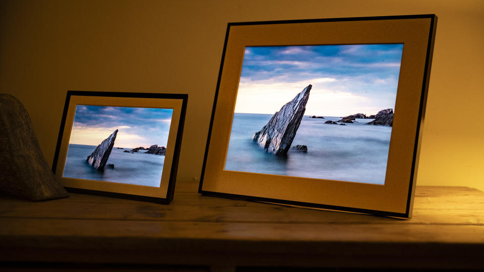 Aura Walden digital photo frame on a wooden sideboard alongside the smaller Aura Carver Mat