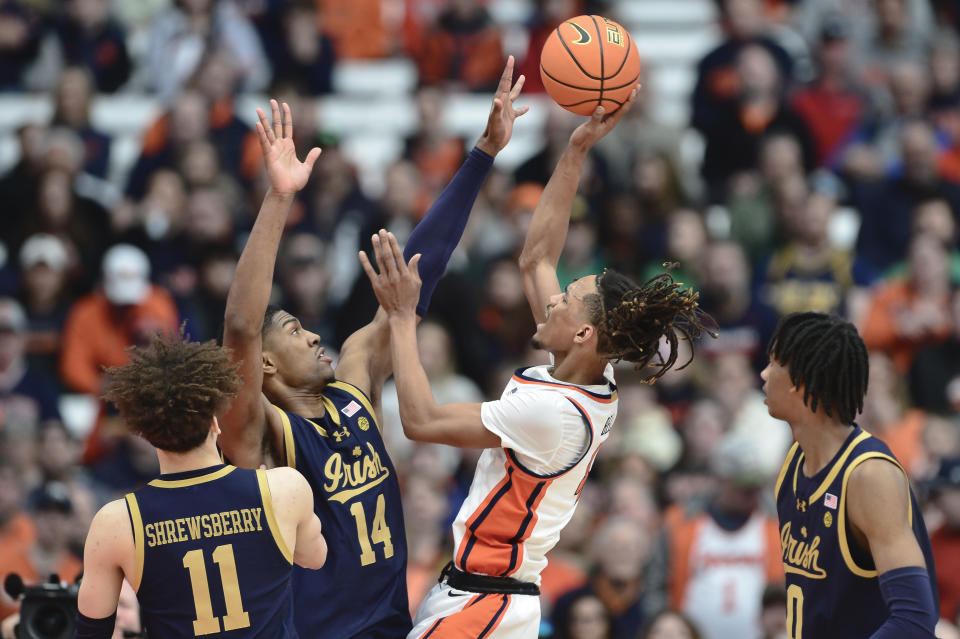 Syracuse forward Chris Bell, right, shoots over Notre Dame forward Kebba Njie during the first half of an NCAA college basketball game in Syracuse, N.Y., Saturday, Feb. 24, 2024. (AP Photo/Adrian Kraus)