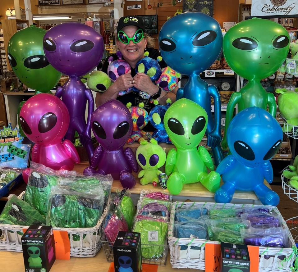 Rose MacDougall, store manager of Trends Gift Gallery, wearing alien-shaped sunglasses for a picture with inflatable aliens. Both items were sold at the store during the UFO Festival this past Labor Day weekend.