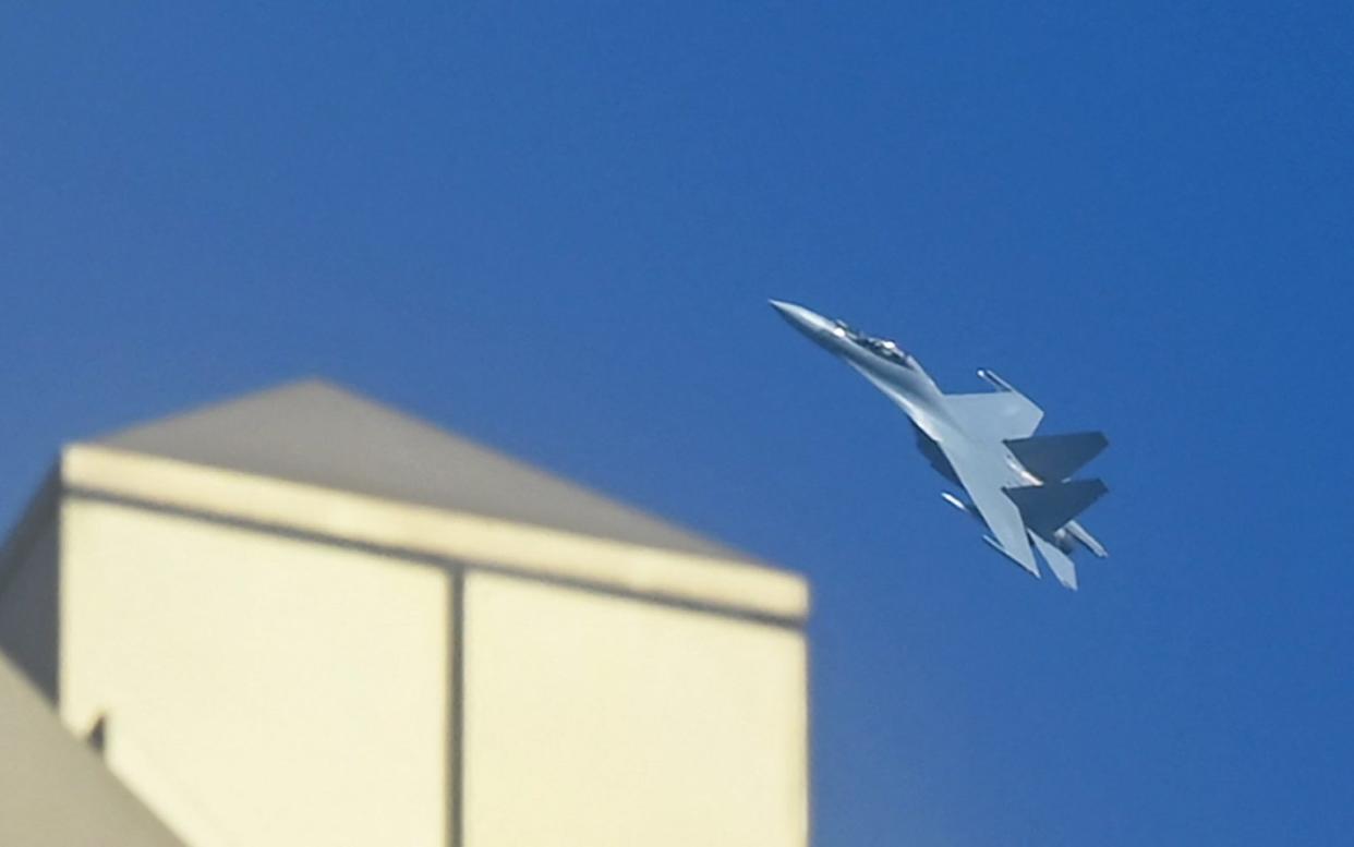 A Chinese jet fighter flies above the buildings on Pingtan Island, the closest point in China to the main island of Taiwan