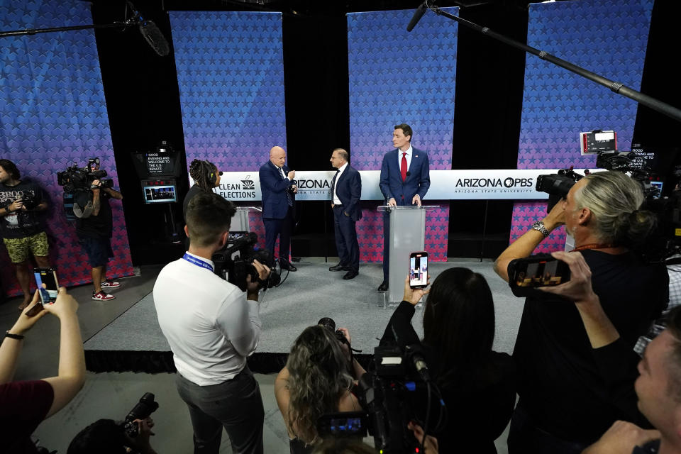 Arizona Democratic Sen. Mark Kelly, left, talks with Libertarian candidate Marc Victor, center, and Republican challenger Blake Masters, right, prior to a televised debate in Phoenix, Thursday, Oct. 6, 2022. (AP Photo/Ross D. Franklin)