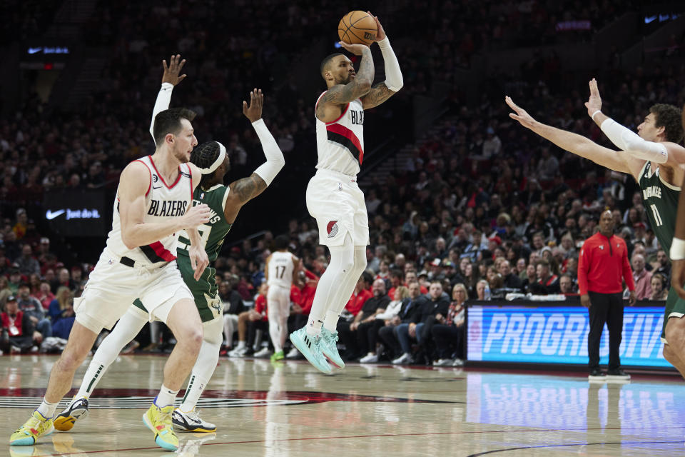 Portland Trail Blazers guard Damian Lillard, center, shoots a 3-point basket over Milwaukee Bucks guard Wesley Matthews, left, and center Brook Lopez during the first half of an NBA basketball game in Portland, Ore., Monday, Feb. 6, 2023. (AP Photo/Craig Mitchelldyer)