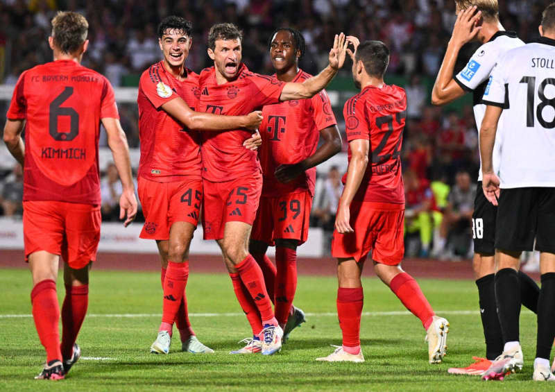 Munich's Thomas Müller celebrates his team's first goal with his teammates during the DFB Cup match between SSV Ulm 1846 and Bayern Munich at the Donaustadion. Tom Weller/dpa