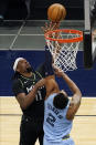 Minnesota Timberwolves' Naz Reid (11) shoots as Memphis Grizzlies' Xavier Tillman defends during the first half of an NBA basketball game Wednesday, May 5, 2021, in Minneapolis. (AP Photo/Jim Mone)