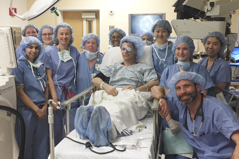 This photo provided by Mass Eye and Ear Phil Durst sits with the surgical team after the first transplant procedure in Boston in April 2018. The experimental procedure aims to treat severe injuries in one eye with stem cells from the other. (Mass Eye and Ear via AP)