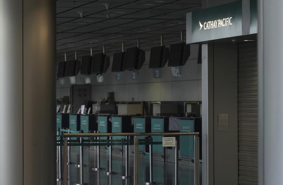 Cathay Pacific empty counters are seen at a train station in Hong Kong Wednesday, Oct. 21, 2020. Hong Kong airline Cathay Pacific Airways on Wednesday said it would cut 8,500 jobs and shut down its regional airline unit in a corporate restructuring, as it grapples with the plunge in air travel due to the pandemic. (AP Photo/Vincent Yu)