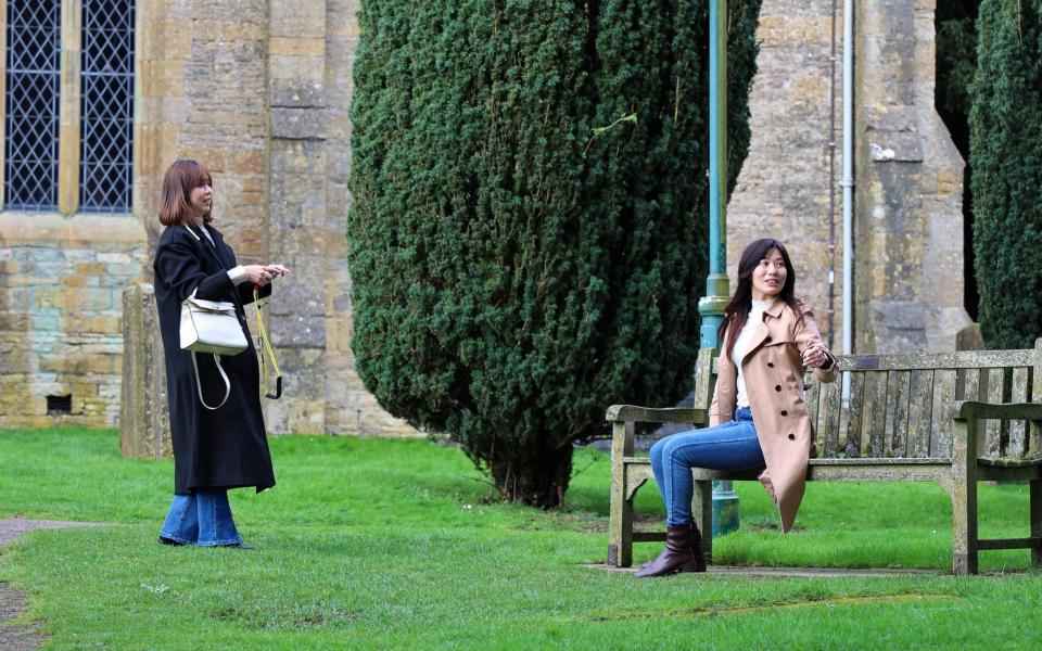 Tourists take photos in the village of Stow in Wold