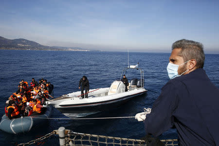 Greek Coast Guard officers tug a dinghy carrying refugees and migrants towards the Agios Efstratios Coast Guard vessel, during a rescue operation at open sea between the Turkish coast and the Greek island of Lesbos, in this February 8, 2016 file photo. REUTERS/Giorgos Moutafis/Files