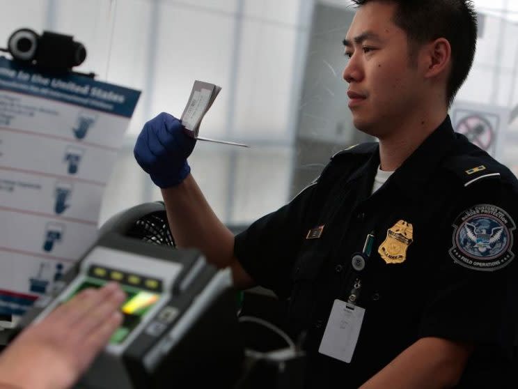 Un agente de aduanas controla la visa de una persona que ingresa a EEUU. (Getty)
