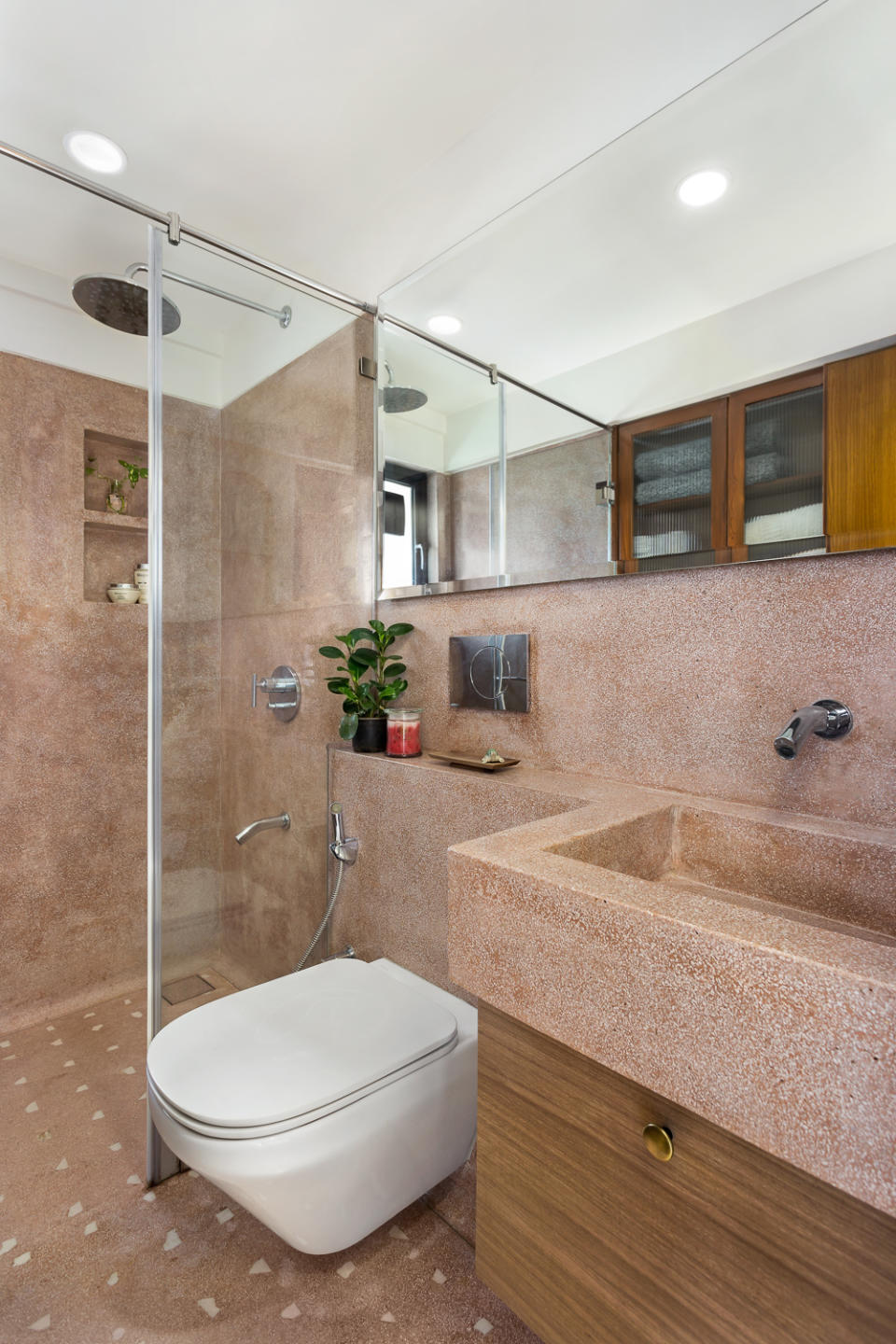 The ensuite bathroom was cast in situ with terrazzo and marble chips that give it a monolithic appeal. A wide mirror here adds to the illusion of space.