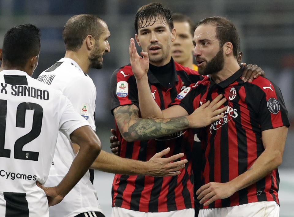 AC Milan's Gonzalo Higuain, right, talks with Juventus' Giorgio Chiellini, left, during a Serie A soccer match between AC Milan and Juventus, at Milan's San Siro stadium, Sunday, Nov. 11, 2018. (AP Photo/Luca Bruno)