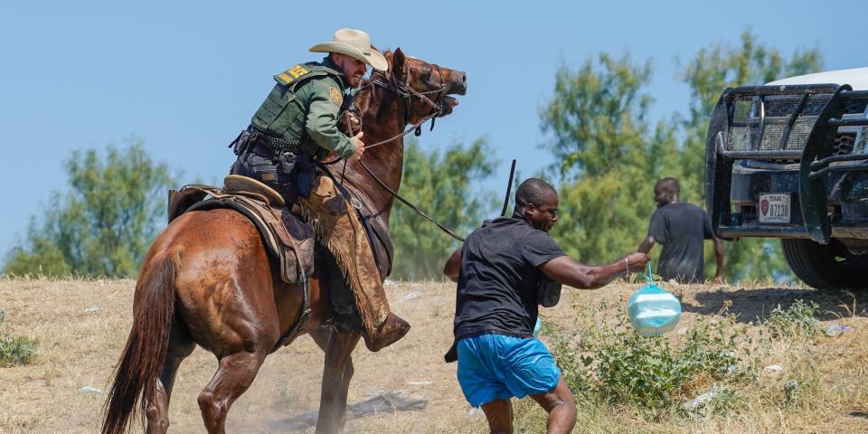 Border Patrol agent on horseback and Haitian migrant