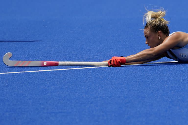 La argentina Sofia Maccari pierde el equilibrio mientras persigue el balón durante un partido de hockey sobre césped femenino contra Australia.