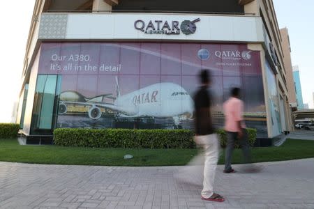 FILE PHOTO: People walk past the Qatar Airways office in Manama, Bahrain, June 8, 2017. REUTERS/Hamad I Mohammed/File Photo