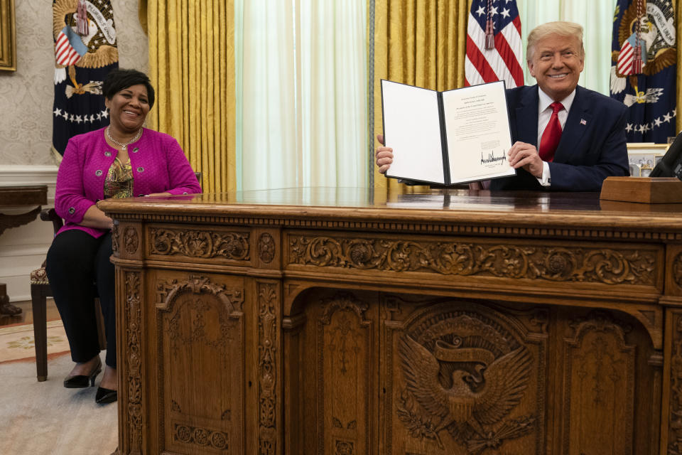 FILE - President Donald Trump and Alice Johnson smile after Trump signed a full pardon for her first-time nonviolent drug offense, in the Oval Office of the White House, Friday, Aug. 28, 2020, in Washington. (AP Photo/Evan Vucci, File)