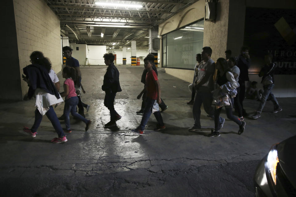 In this July 18, 2019 photo, migrants who have just been bused by Mexican Authorities from Nuevo Laredo to Monterrey, walk off the bus into the street in Monterrey, Mexico. All those taken to Monterrey who spoke with AP said that they had not asked for asylum in the US and some asked to be returned to their home countries, but were told that going to Mexico or remaining in detention were the only options. (AP Photo/Marco Ugarte)