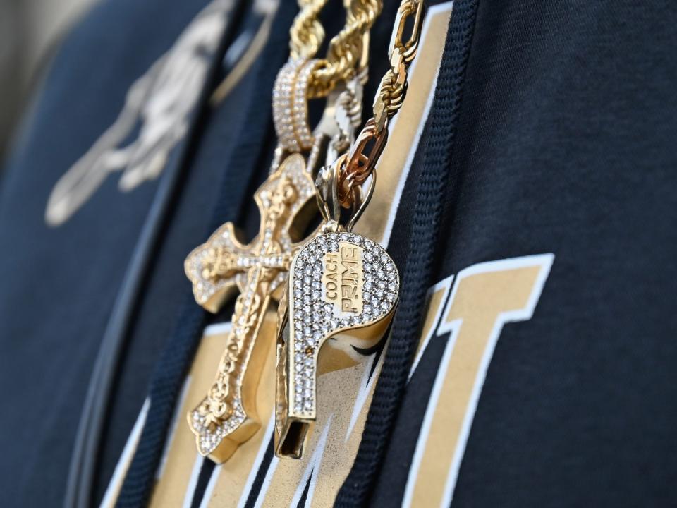 Deion Sanders wears a diamond-encrusted gold whistle and cross around his neck.