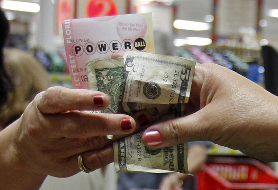 A customer buys three Powerball tickets at a local supermarket in Hialeah, Fla.,Tuesday, Nov. 27, 2012. There has been no Powerball winner since Oct. 6, and the jackpot already has reached a record level for the game. Already over $500 million, it is the second-highest jackpot in lottery history, behind only the $656 million Mega Millions prize in March.  (AP Photo/Alan Diaz)