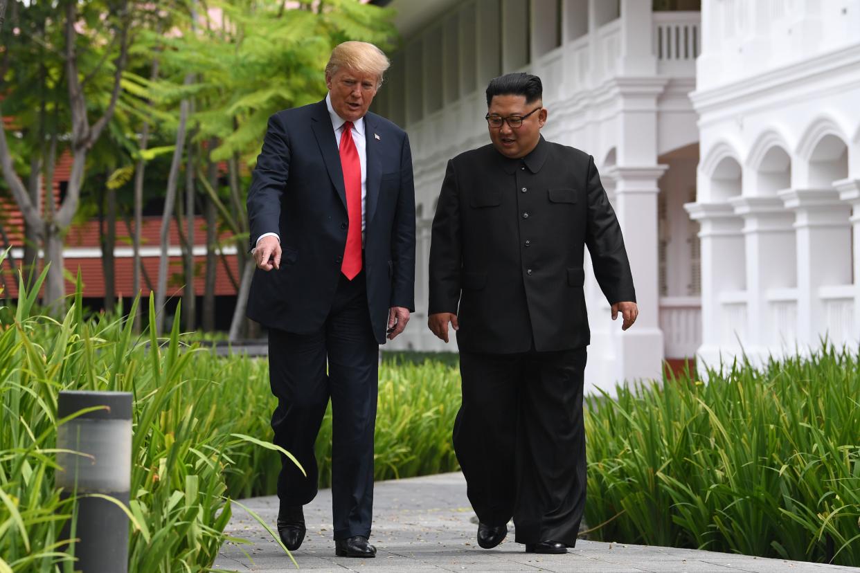 North Korean leader Kim Jong Un (right) walks with US President Donald Trump during a break in talks at their historic US-North Korea summit, at the Capella Hotel on Sentosa, Singapore, on June 12, 2018. (PHOTO: AFP via Getty Images)