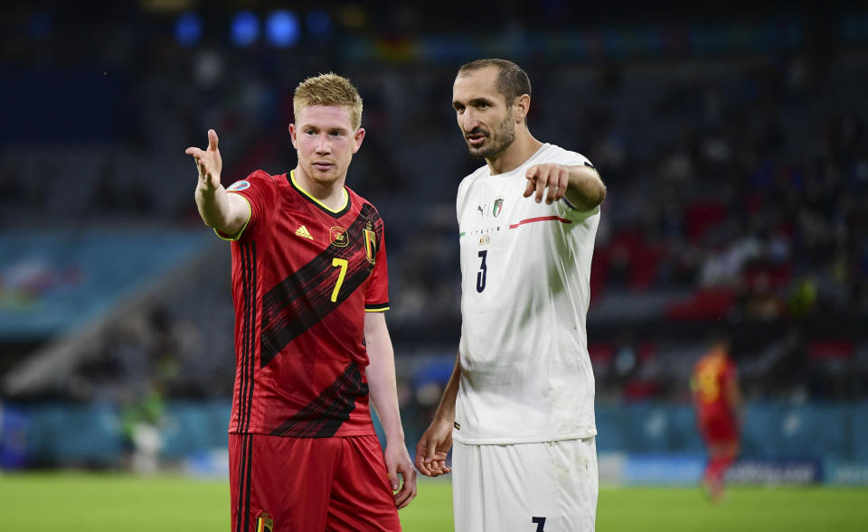 Belgium's Kevin De Bruyne, left, talks with Italy's Giorgio Chiellini during the Euro 2020 soccer championship quarterfinal match between Belgium and Italy at at the Allianz Arena in Munich, Germany, Friday, July 2, 2021. (AP Photo/Philipp Guelland, Pool Photo via AP)
