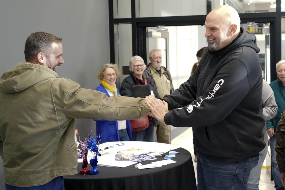 In this photo made on Friday, March 4, 2022, Pennsylvania Lt. Gov. John Fetterman, right, greets Brian Sims, a candidate for Pennsylvania Lt. Governor, as they visit with people attending a Democratic Party event for candidates to meet and collect signatures for ballot petitions for the upcoming Pennsylvania primary election, at the Steamfitters Technology Center in Harmony, Pa. Fetterman is running for the party nomination for the U.S. Senate. The irreverent, blunt, 6 feet 8, tattooed Fetterman faces the Pennsylvania's Democratic Party committee backed U.S. Rep. Conor Lamb and Malcolm Kenyatta, a second-term state representative from Philadelphia. (AP Photo/Keith Srakocic)