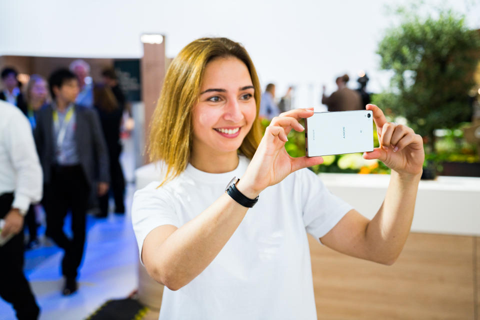 A woman takes a picture with an Xperia phone.