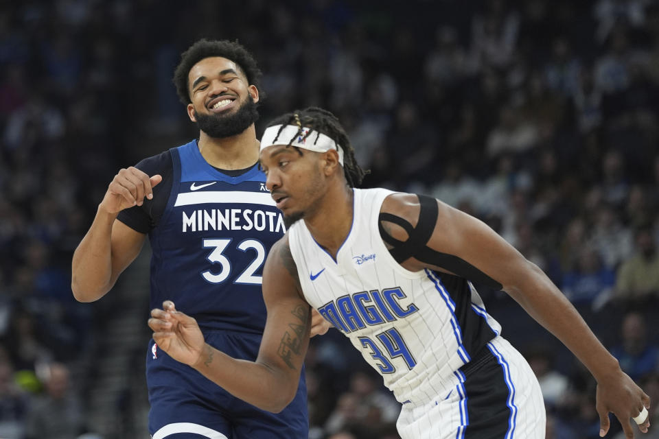 Minnesota Timberwolves center Karl-Anthony Towns (32) reacts next to Orlando Magic center Wendell Carter Jr. (34) after missing a shot during the first half of an NBA basketball game, Friday, Feb. 2, 2024, in Minneapolis. (AP Photo/Abbie Parr)