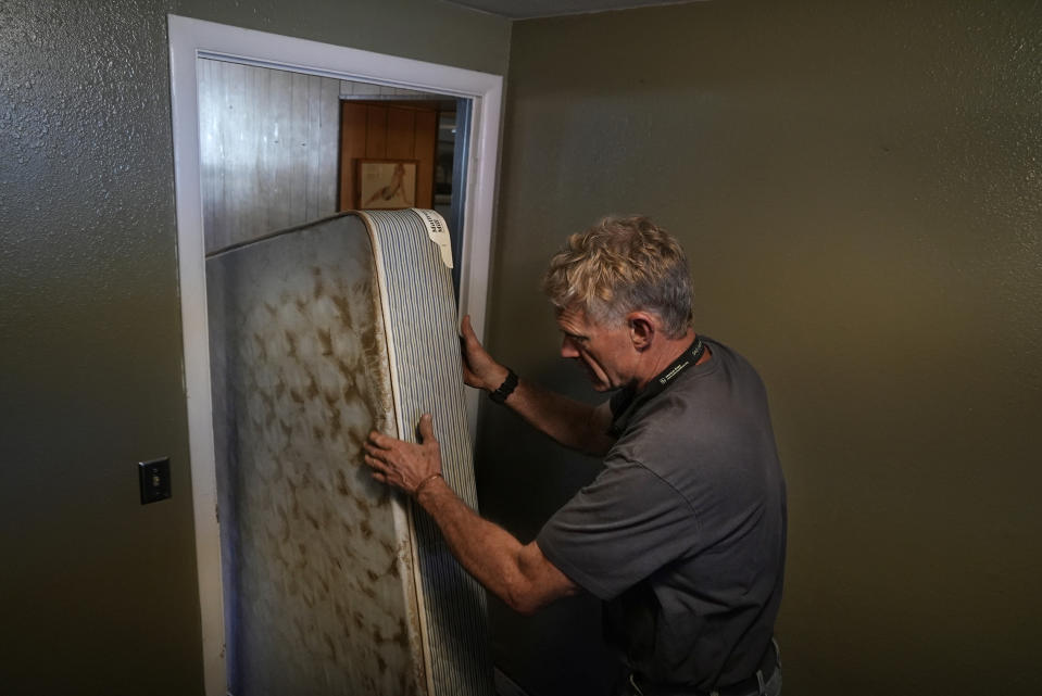 Mac Dean, owner of the Yodeler Motel, moves a water-logged mattress from a lower level room Thursday, June 16, 2022, in Red Lodge, Mont. His business was one of about 250 buildings that flooded in Carbon County when torrential rains swelled waterways across the Yellowstone region. (AP Photo/Brittany Peterson)