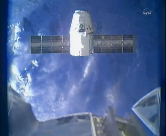 A private SpaceX Dragon cargo capsule hovers below the International Space Station on March 3, 2013, just before being captured by the outpost's robotic arm to deliver 1,200 pounds of cargo for NASA during the CRS-2 mission (SpaceX2).