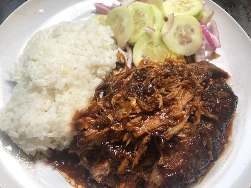 a plate with roasted pork shoulder, rice and pickled vegetables