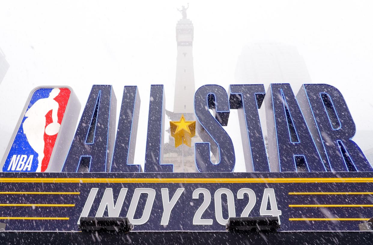 Snow falls Friday, Feb. 16, 2024, in front of an NBA All-Star Indy 2024 sign on Monument Circle in Indianapolis.