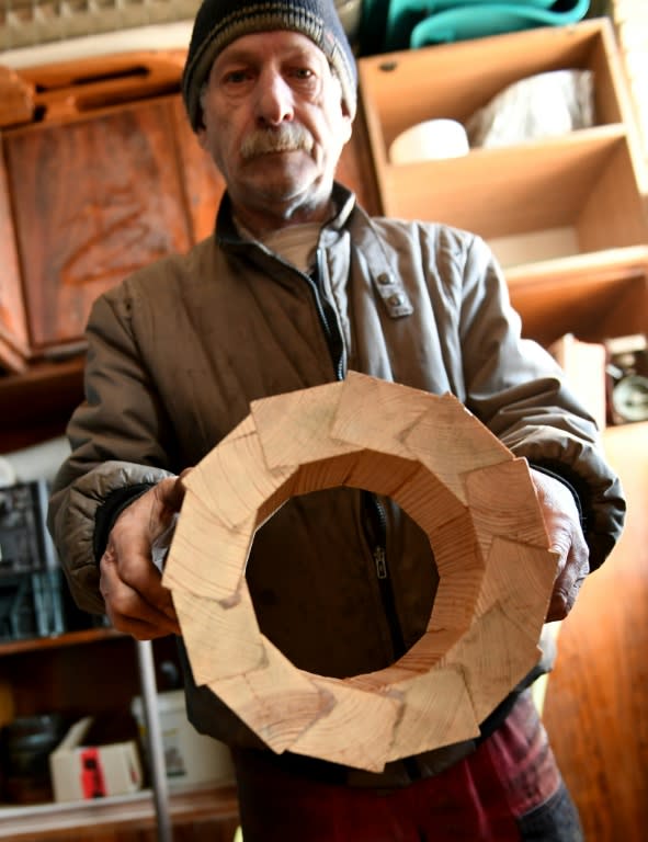 Michal Jedynak shows a mast pattern for a steel schooner named 'Father Boguslaw' under construction at the courtyard of a homeless shelter run by Catholic Fathers, in Warsaw