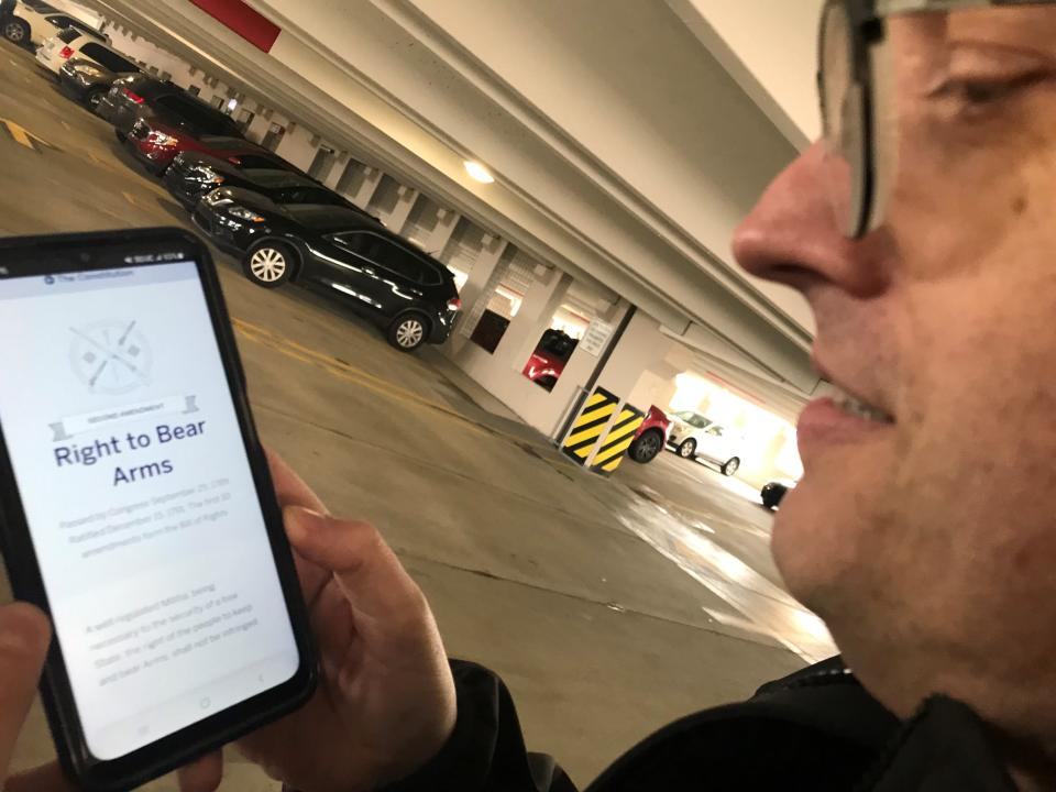 John Kulesz, of Troy, standing in a Royal Oak parking deck on Oct. 27, 2023, displays the copy of the U.S. Constitution's Bill of Rights that he keeps in his cellphone, including the Second Amendment, which protects the right to bear arms. Kulesz, a lawyer and expert on constitutional law, moderates occasional forums in Troy and at Oakland University, at which the public is invited to discuss constitutional rights.