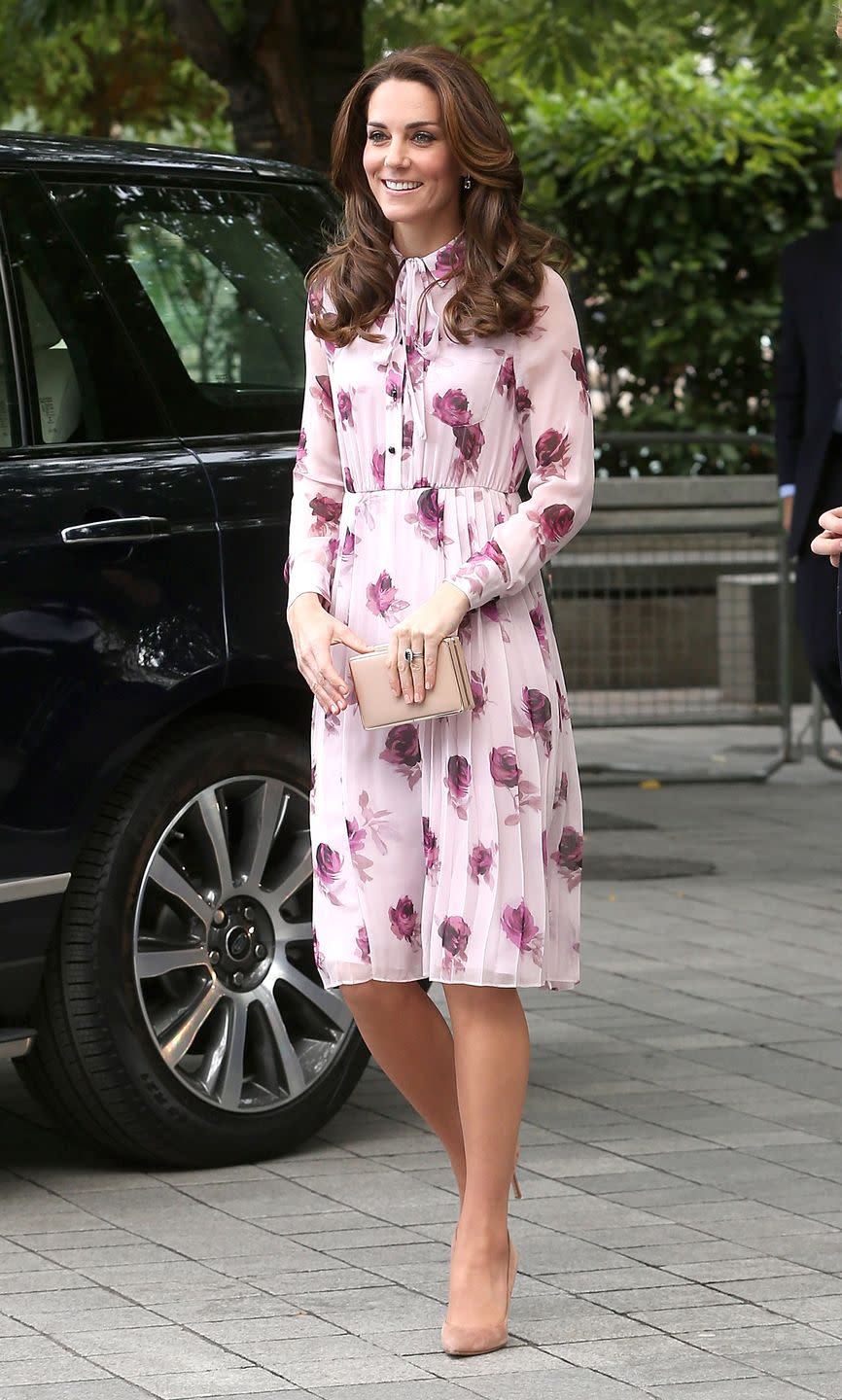 <p>Middleton wears a light pink chiffon Kate Spade dress with a rose pattern, a tie neck and pleated skirt, paired with a nude clutch and suede heeled pumps at while celebrating at World Mental Health Day in London. </p>